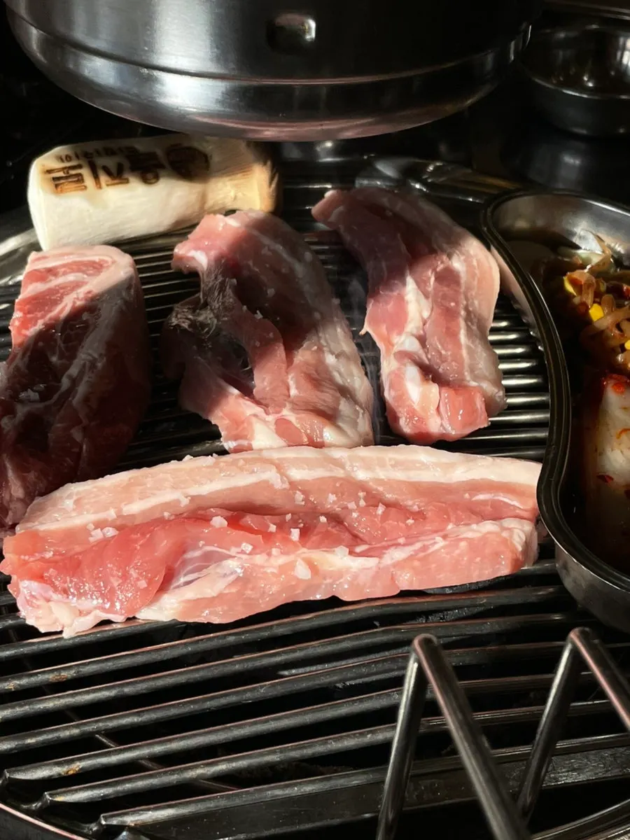 Pork belly sizzling on the charcoal grill