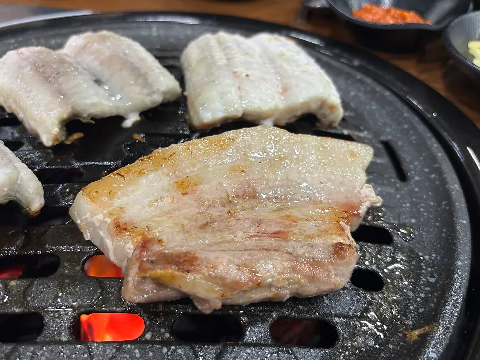 Pork belly grilling alongside eel