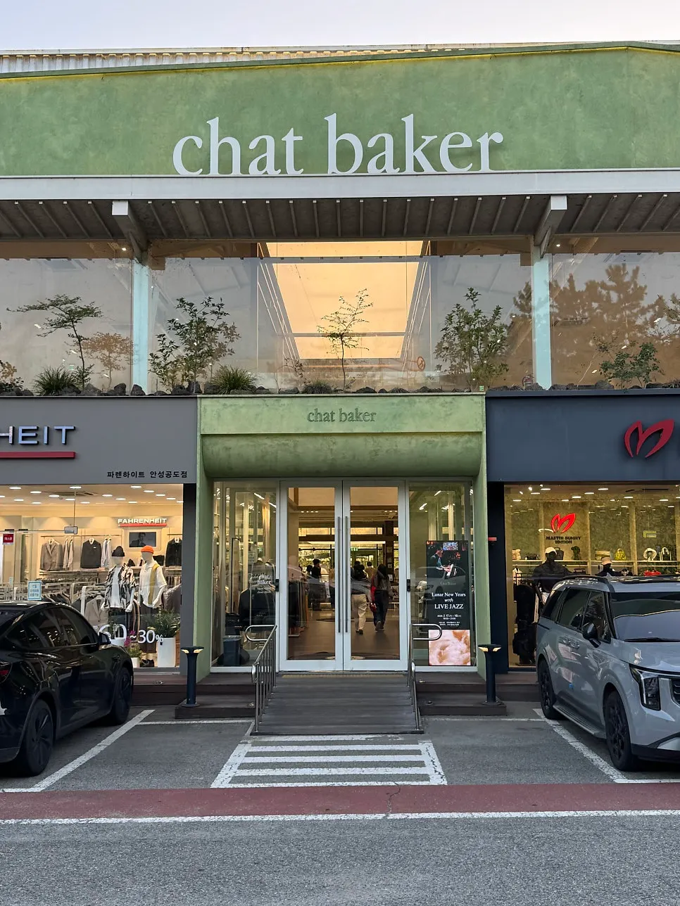 Café exterior with a green sign and floor-to-ceiling windows