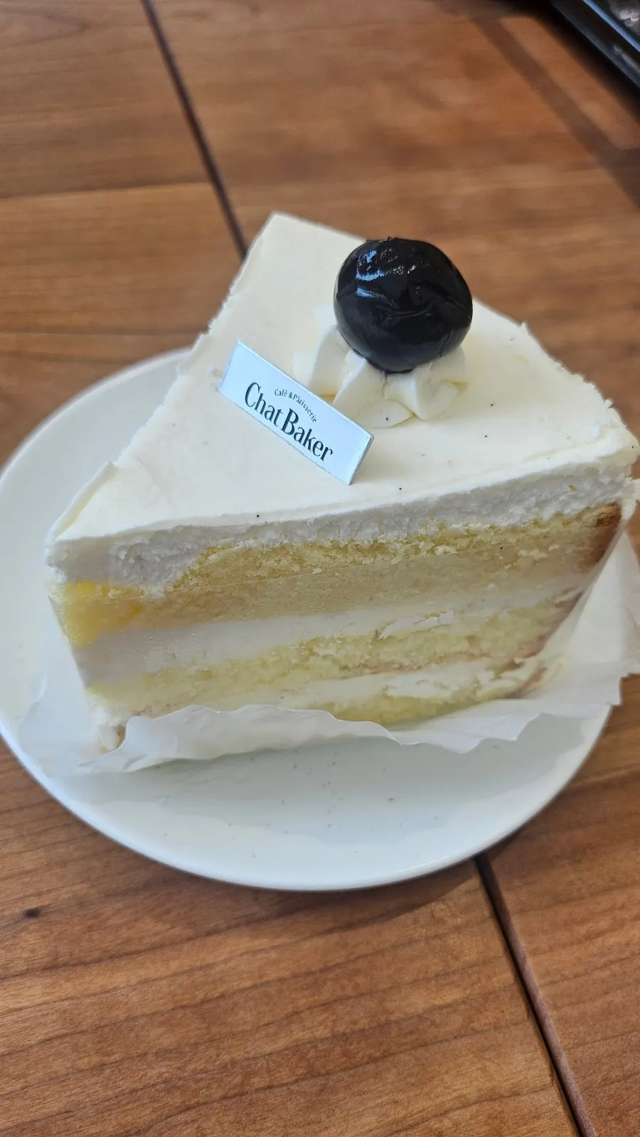 A slice of cream cake served alongside coffee