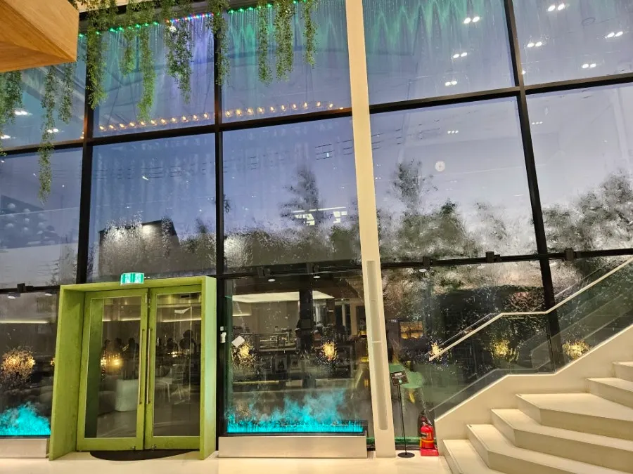 Mặt tiền cafe lớn với ánh đèn dịu và tường kính lớn