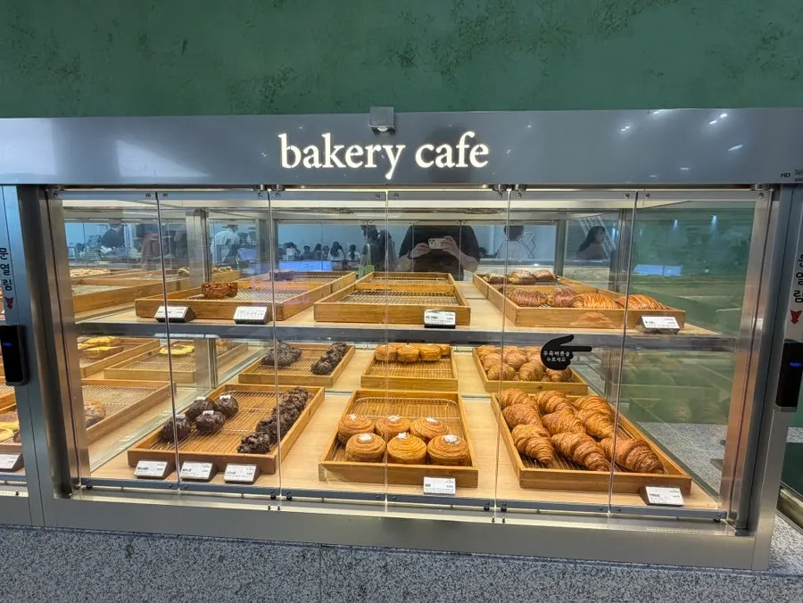 Picking out bread with a tray at the display case