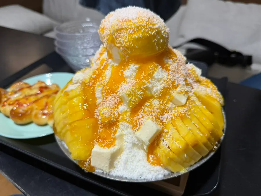 Fresh mango bingsu topped with ice cream and cubed cream cheese