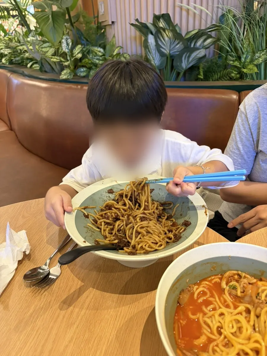 Child eating jajangmyeon with chopsticks