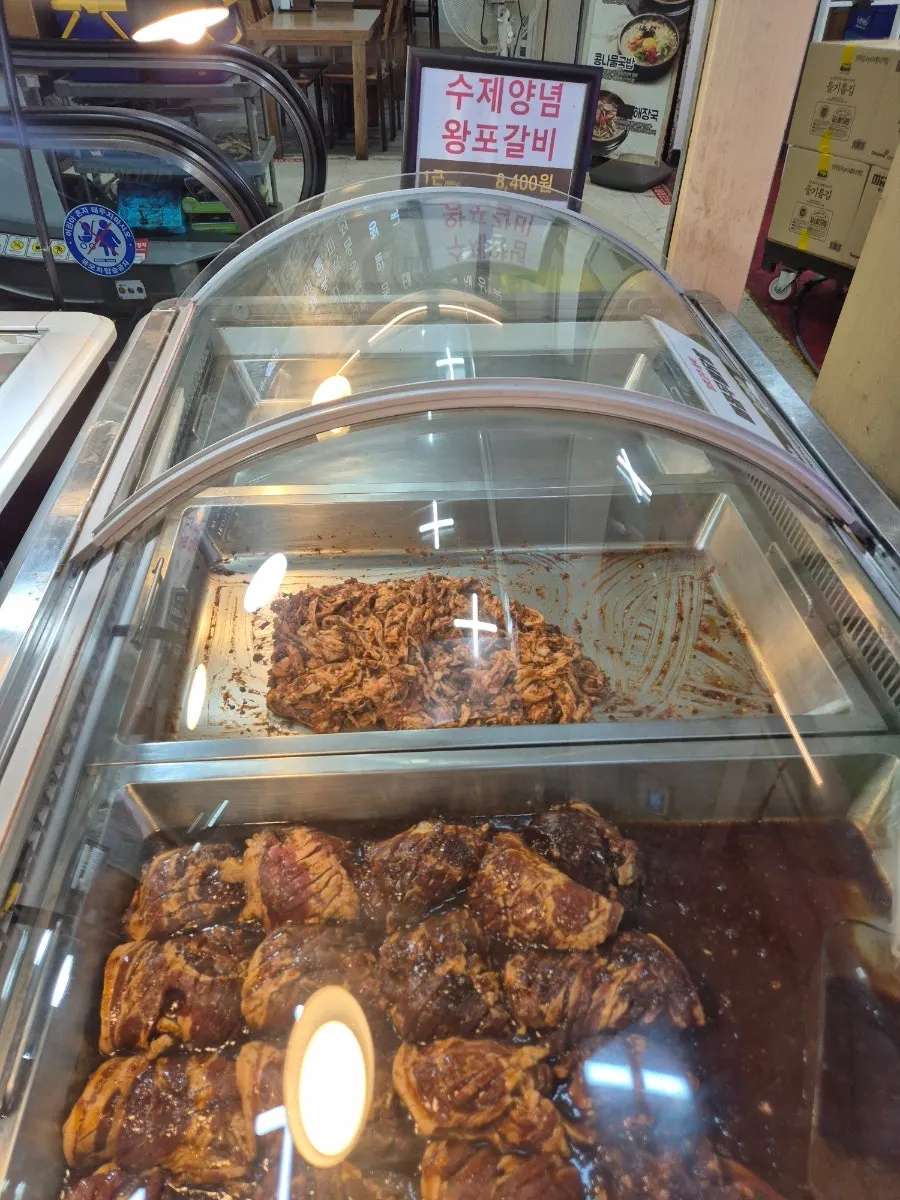Marinated meats sitting in the butcher shop's display case