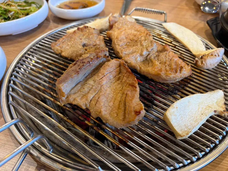 Marinated pork ribs and king oyster mushrooms on the charcoal grill
