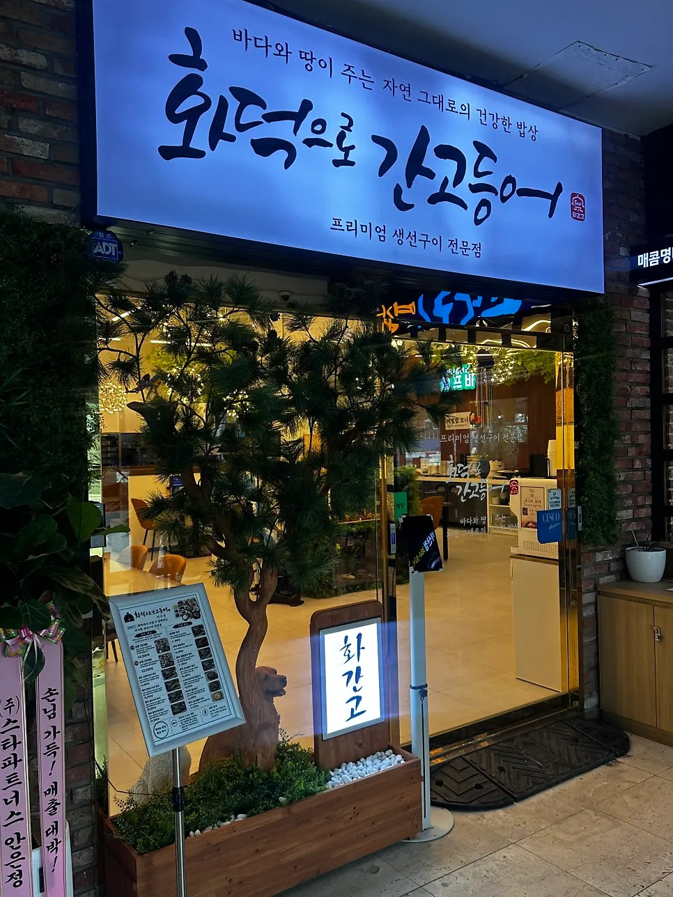 소나무 조경이 있는 매장 입구