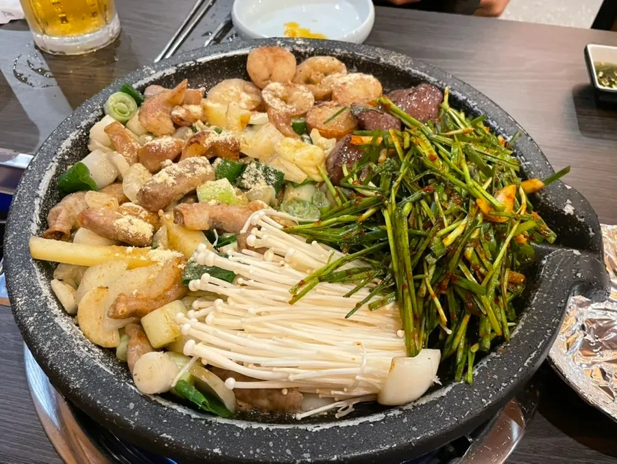 Two servings of assorted gopchang on the grill