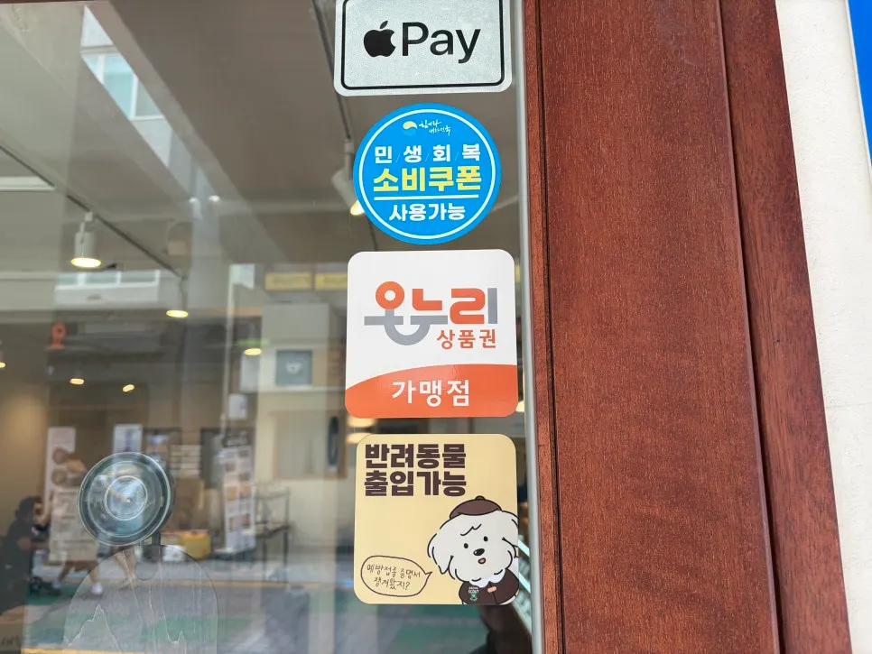 Sign about dog-friendly entry and payment options at Saechamcoffee