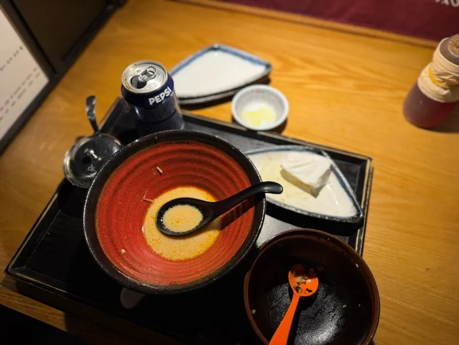 Scooping up a spoonful of ramen broth