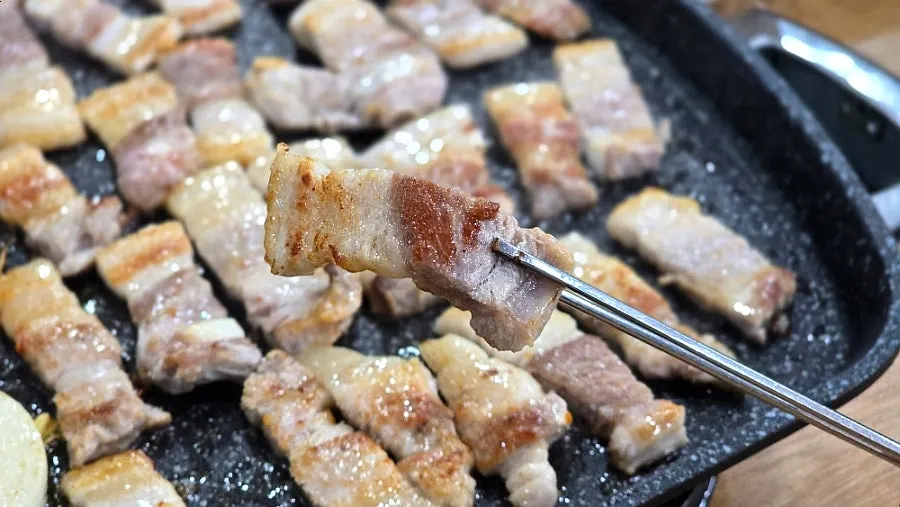 Grill filled with pork belly and side vegetables