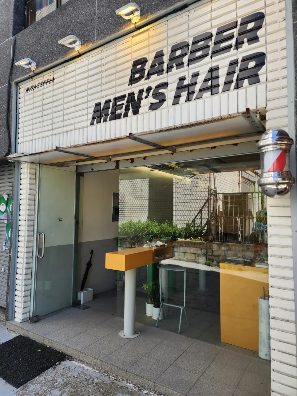 Exterior of Coup Barber & Coffee with barber pole