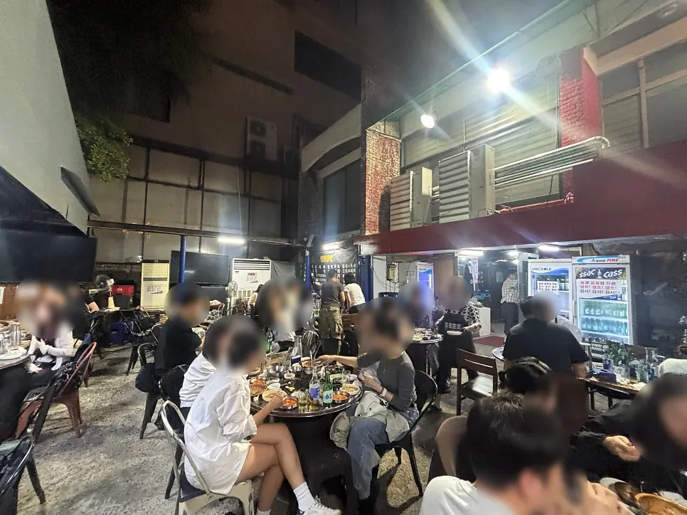 Busy outdoor dining tables filled with people