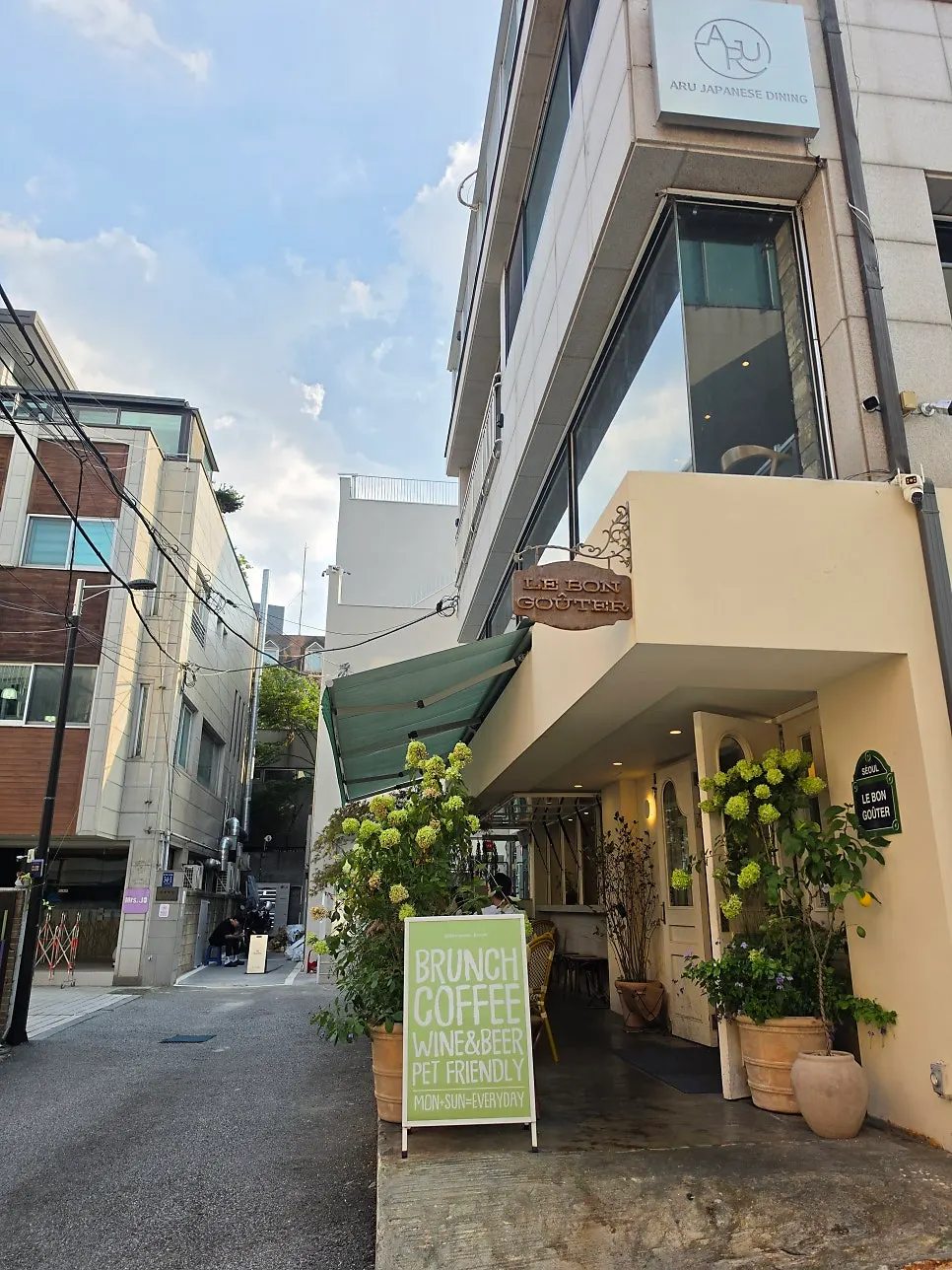 Exterior of Le Bon Goûter in a quiet alley near Dosan Park