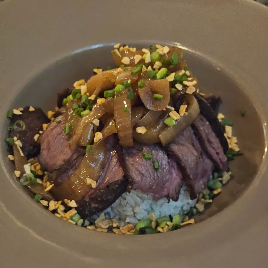 Grilled onion and wasabi placed on top of the steak