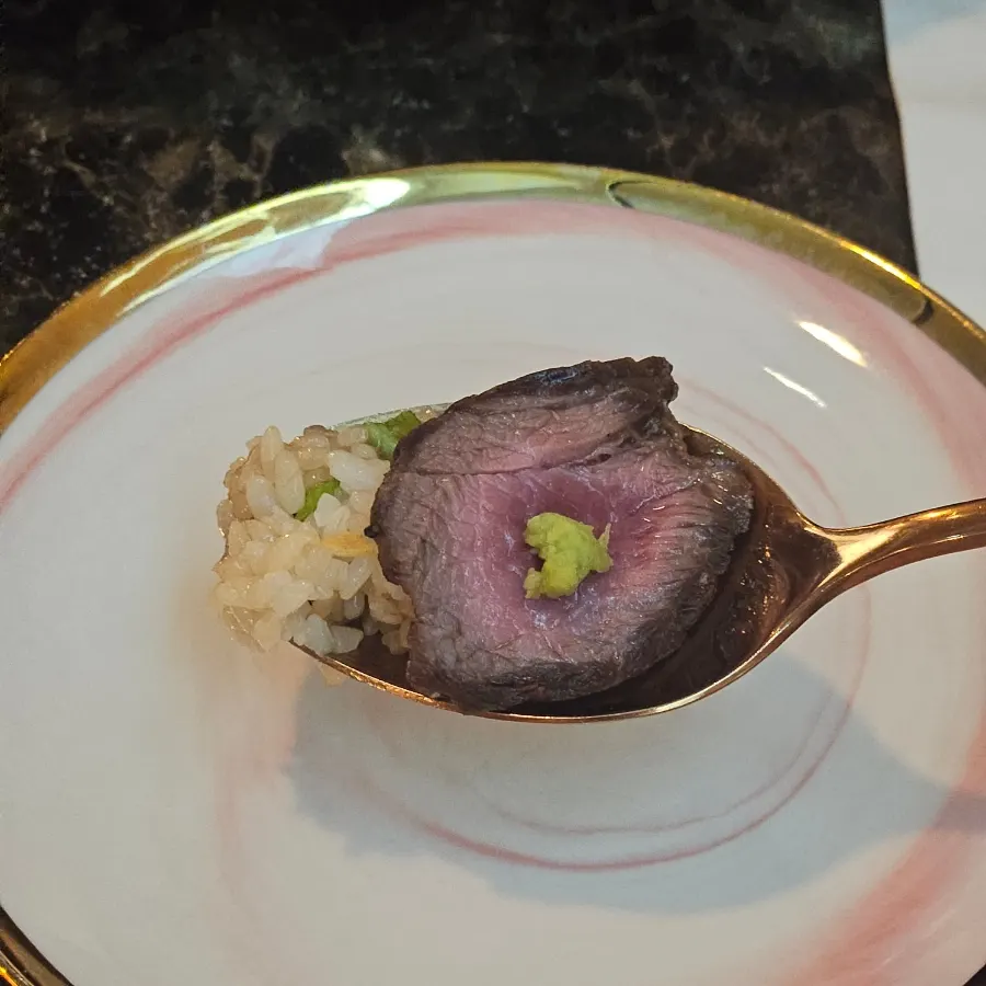 Eating the rose steak rice bowl in one bite with rice