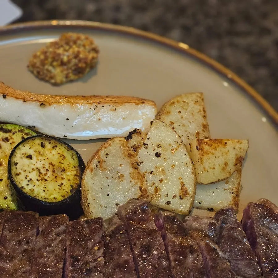 Grilled vegetables including tomato, zucchini, eggplant, and potato