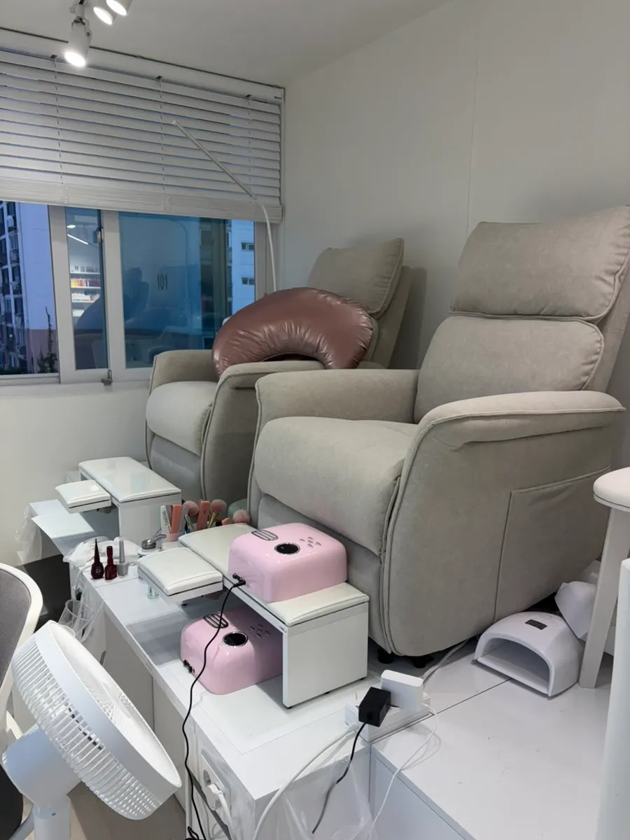 Wide view of the spacious white-toned nail salon interior