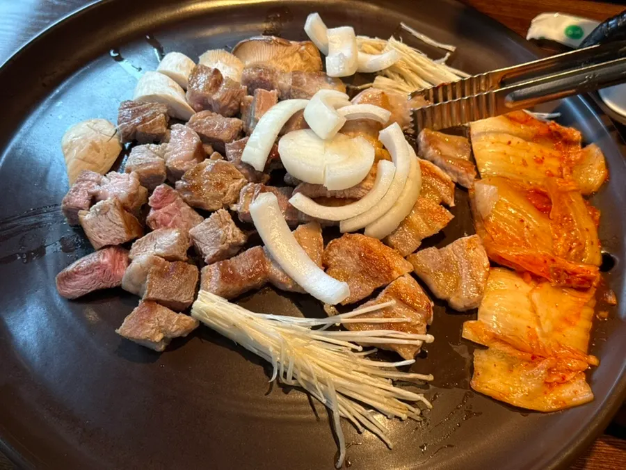 Pork belly grilling on an earthenware grill