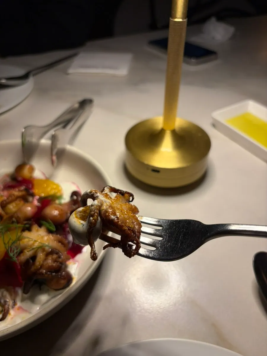 Octopus potato being served onto a plate