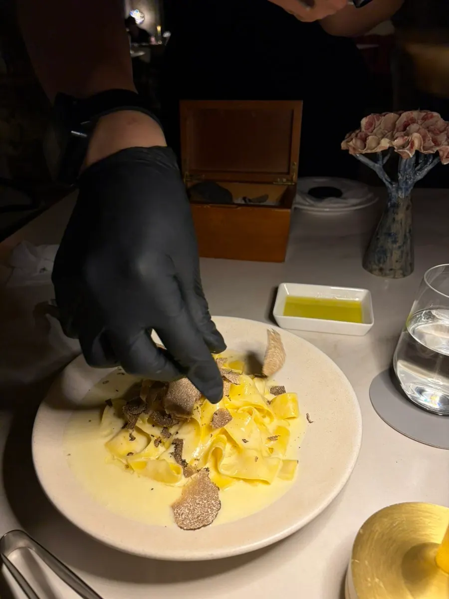 Cheese wheel tagliatelle topped with fresh truffle