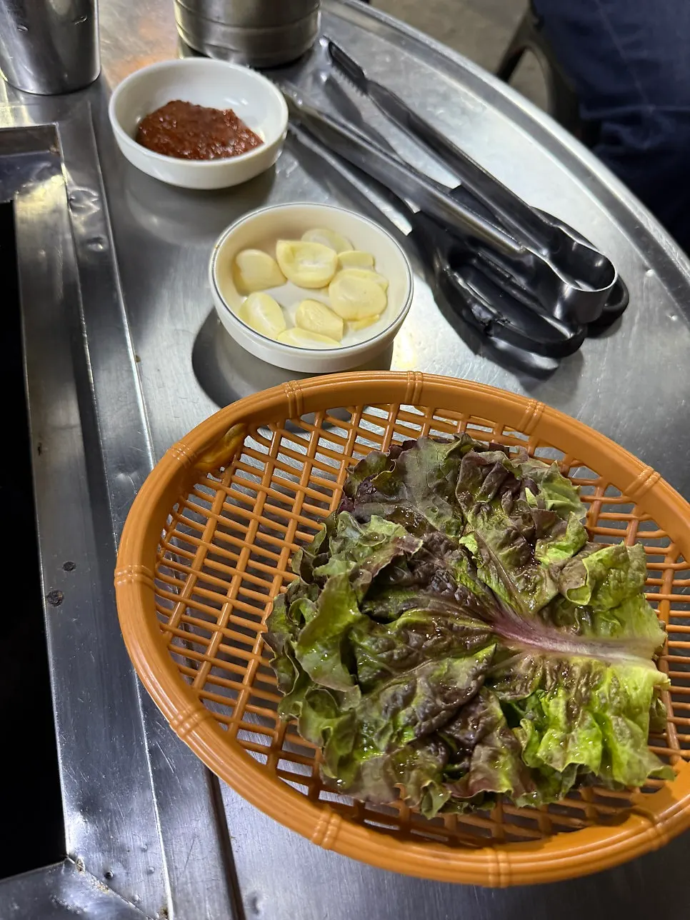 A spread of side dishes including seasoned bean sprouts, napa cabbage kimchi, and dongchimi