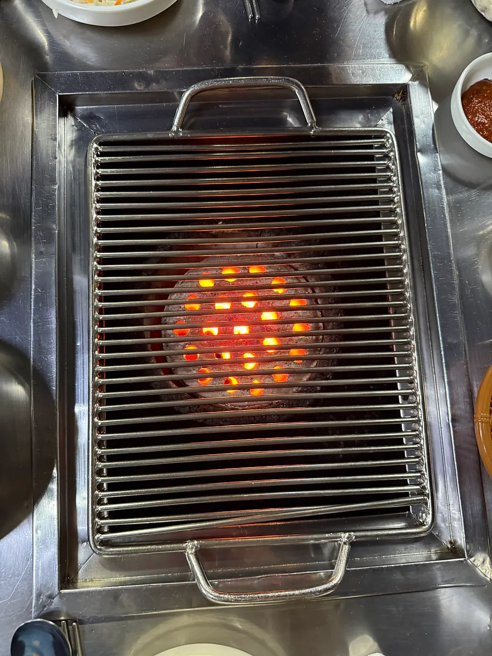 A charcoal briquette grill placed on the table