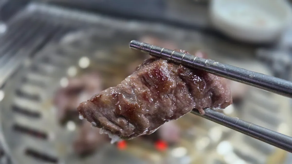 Close-up of beef short rib grilling over charcoal