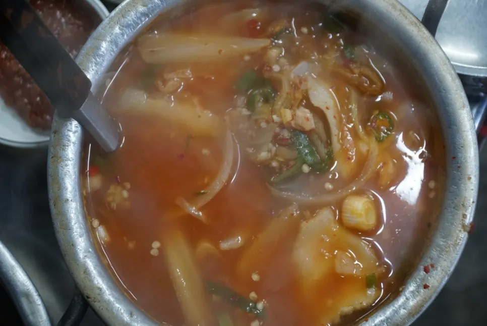 Kimchi jjigae soup served alongside the meat