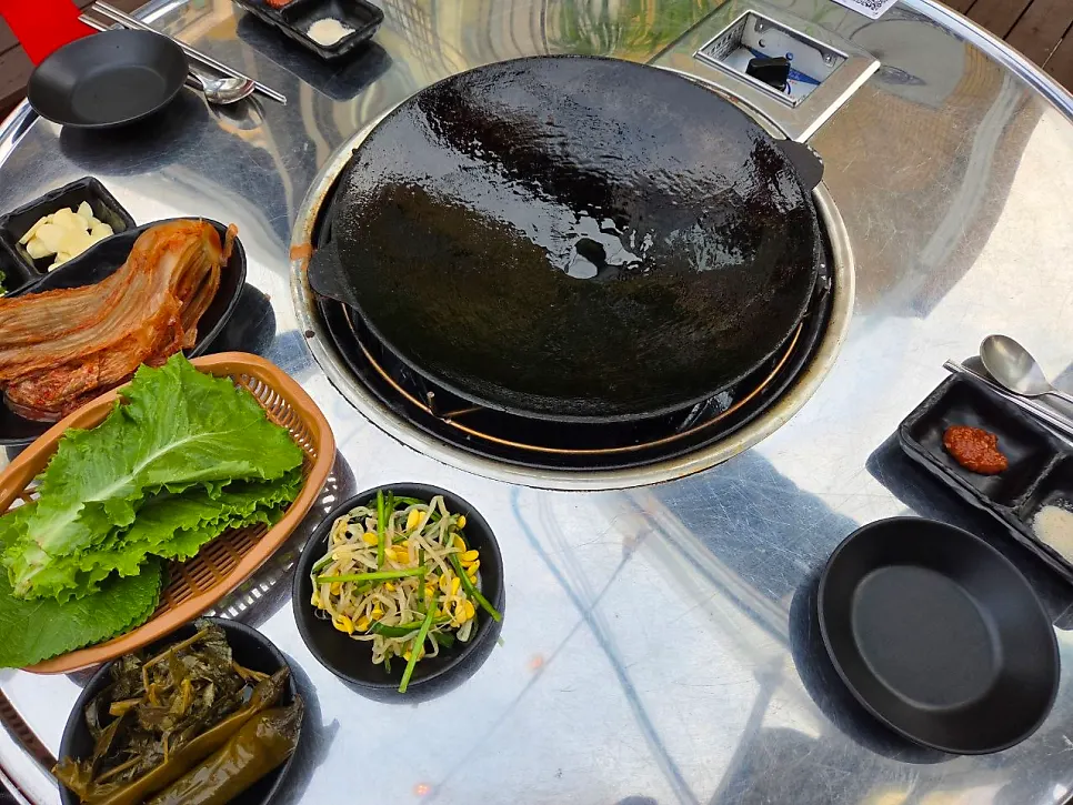 Bean sprouts and other side dishes served alongside the meat