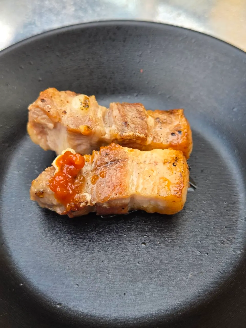 Close-up of the pork belly cut into bite-sized pieces as it cooks