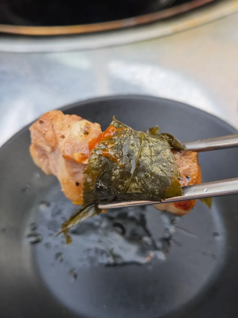 Pre-seared pork belly wrapped in perilla leaf and lettuce