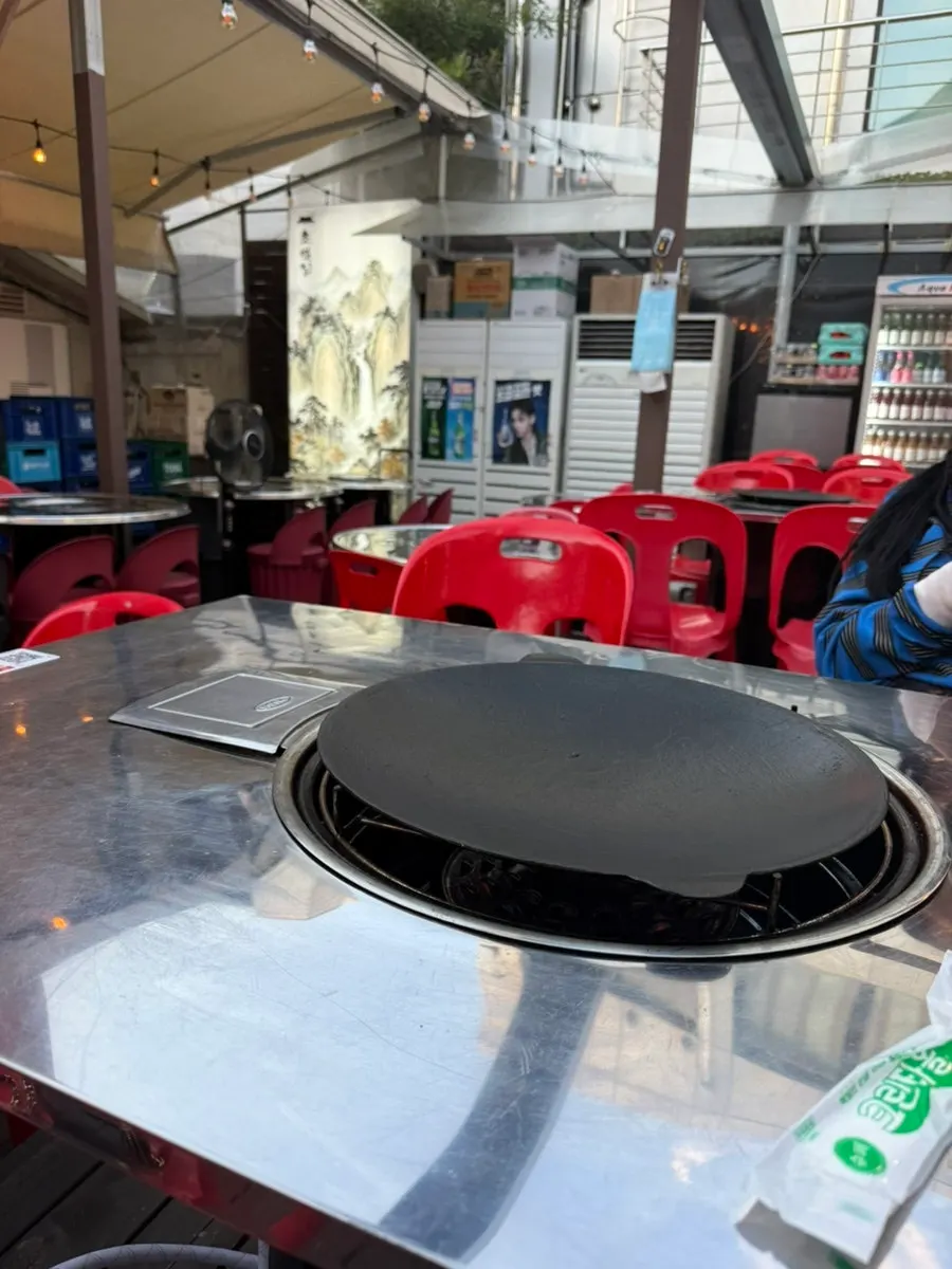 Round stainless steel table set with a cauldron-lid griddle