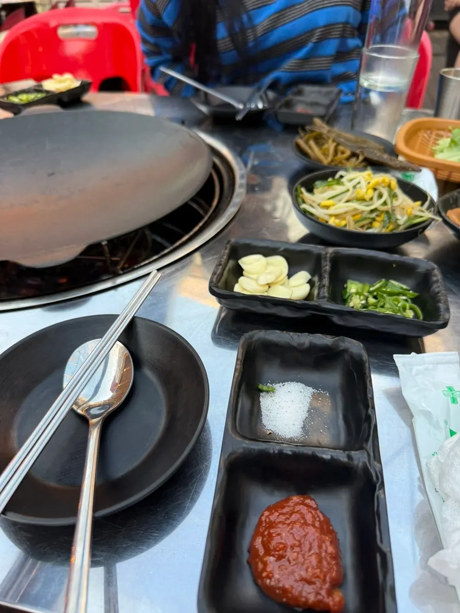 Individual sauce plate with salt and ssamjang, plus sliced garlic and cheongyang chili peppers