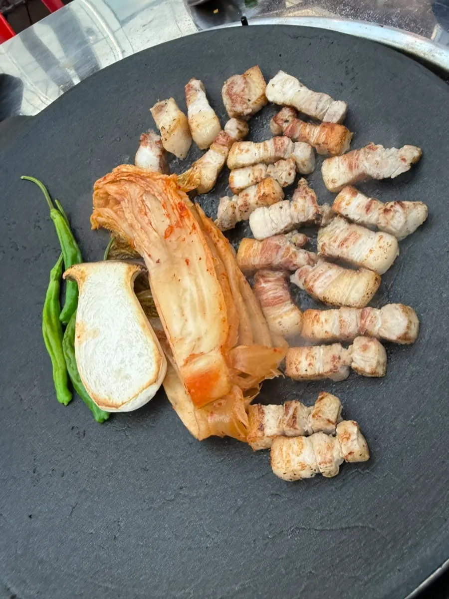 Sliced grilled pork belly with mushrooms browned in kimchi oil