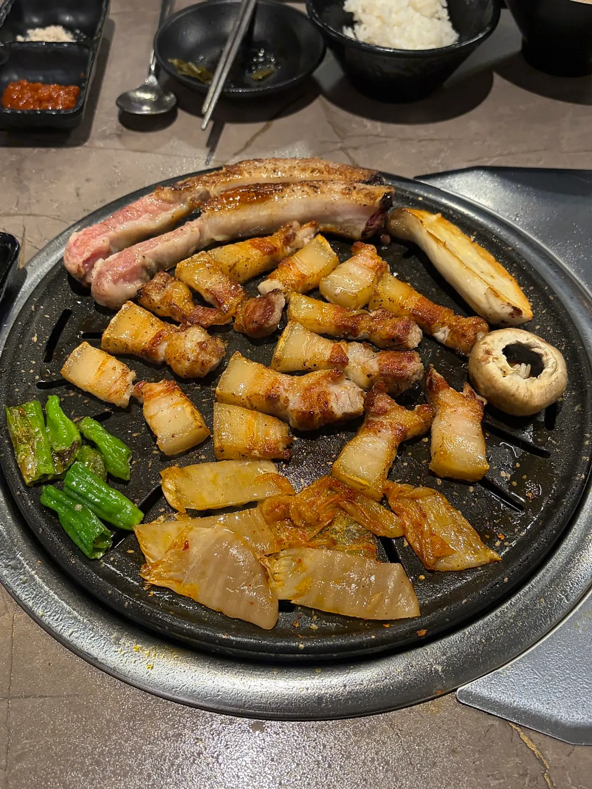 Bone pork belly on the griddle with kimchi and mushrooms