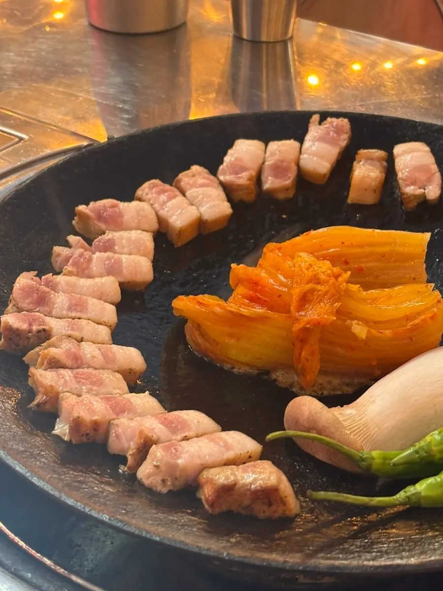 Pre-seared pork belly and whole aged kimchi on the griddle