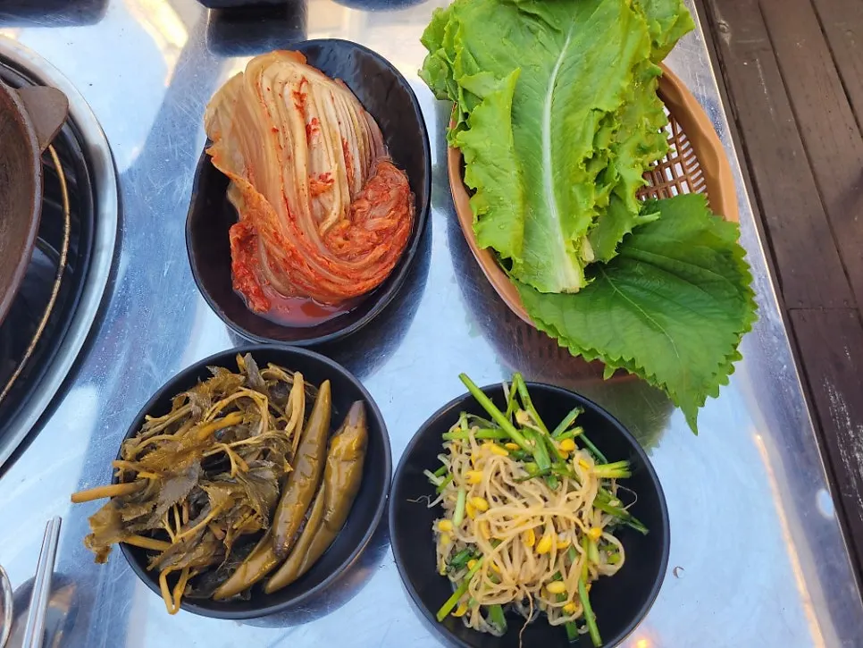 Aged kimchi and ssam vegetables served as complimentary sides
