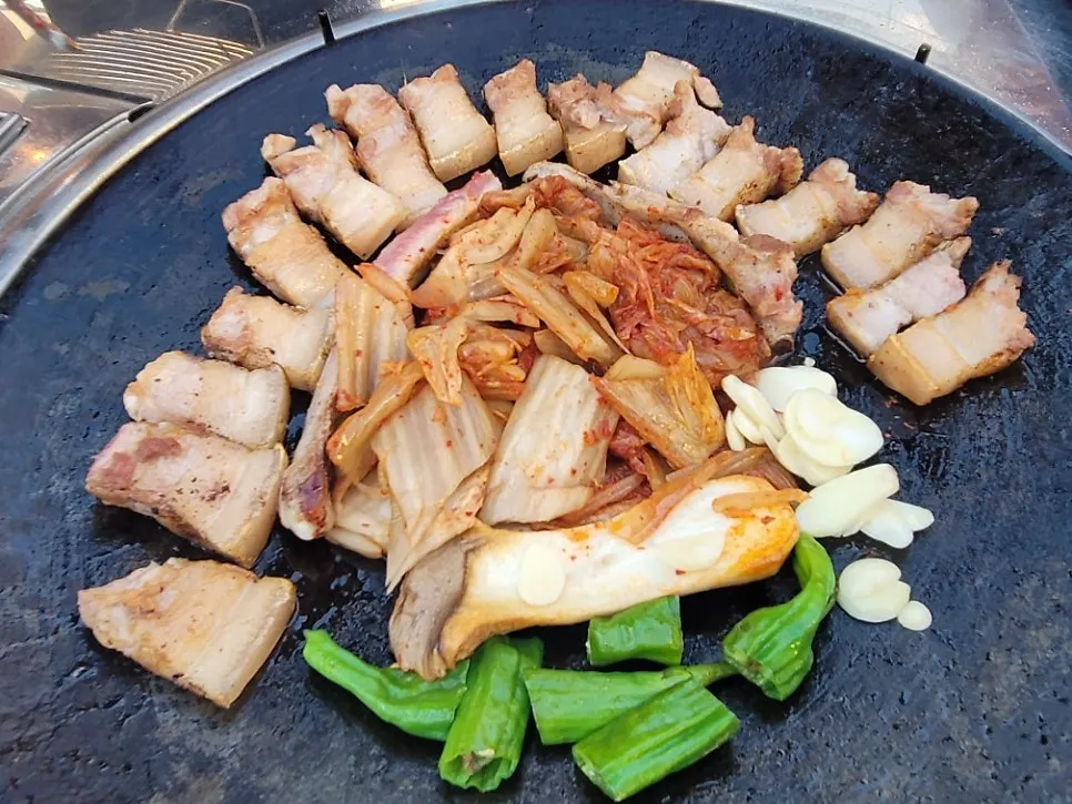 Pork belly served with king oyster mushrooms and peppers