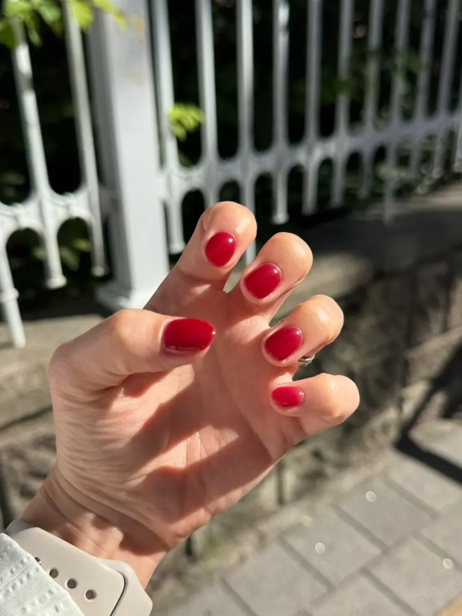 Vivid cherry red one-color nails under sunlight
