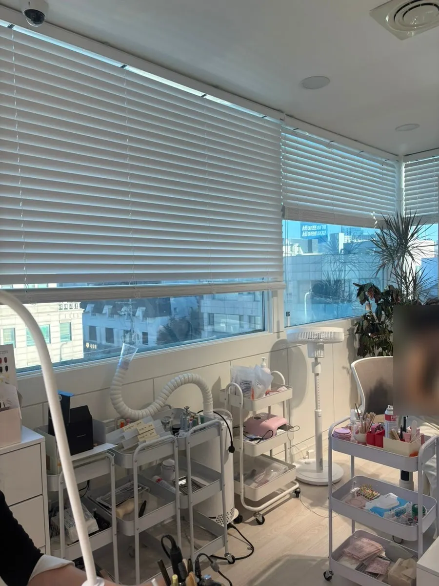 Clean white-toned waiting area of the nail salon