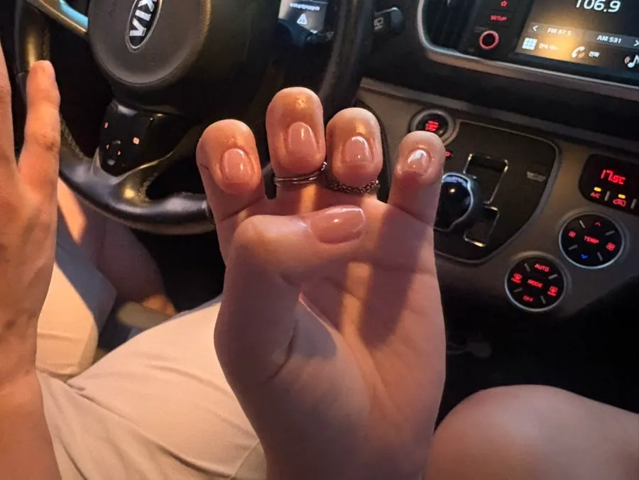 Both hands showing off the nude-tone nails