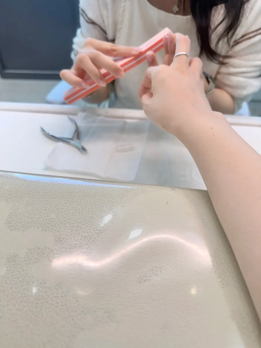 네일 시술을 받고 있는 손