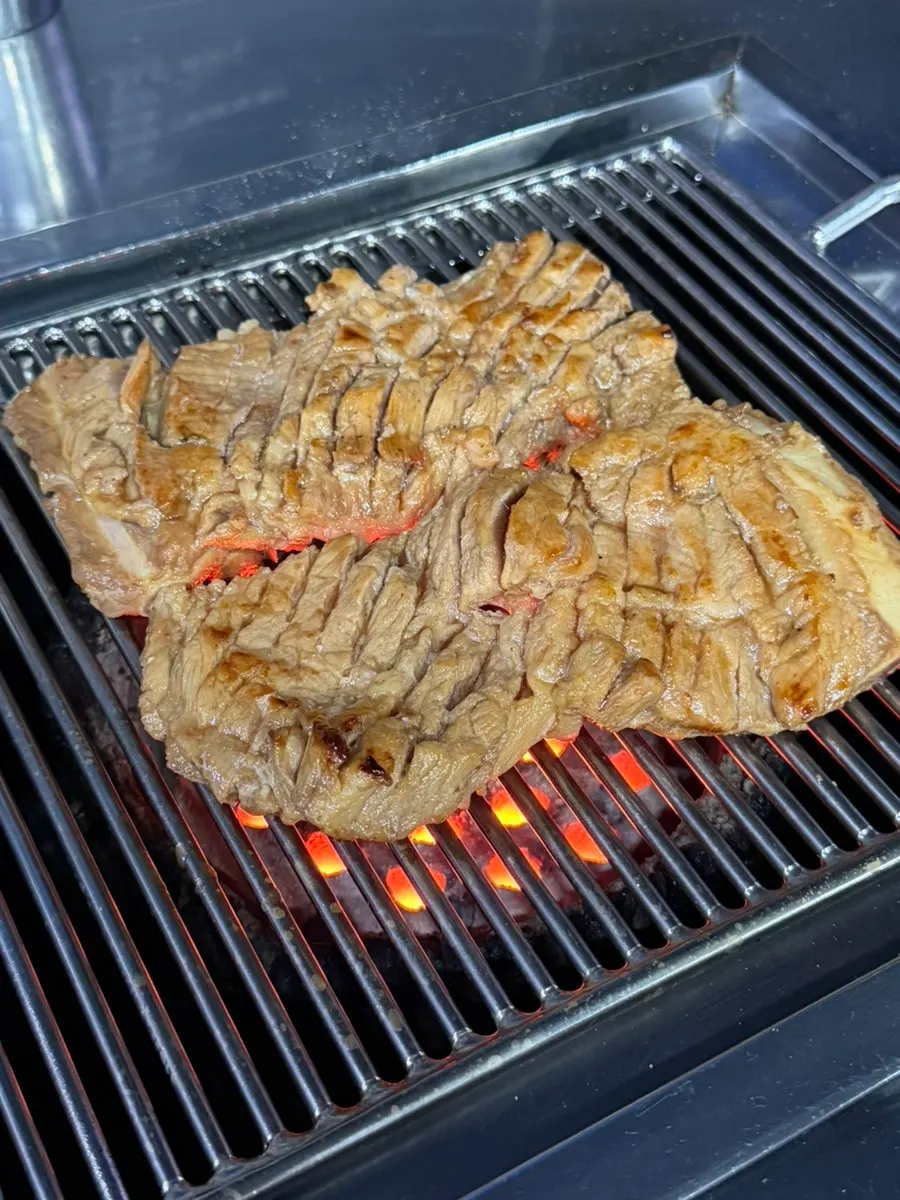 Seasoned pork ribs placed on the charcoal grill