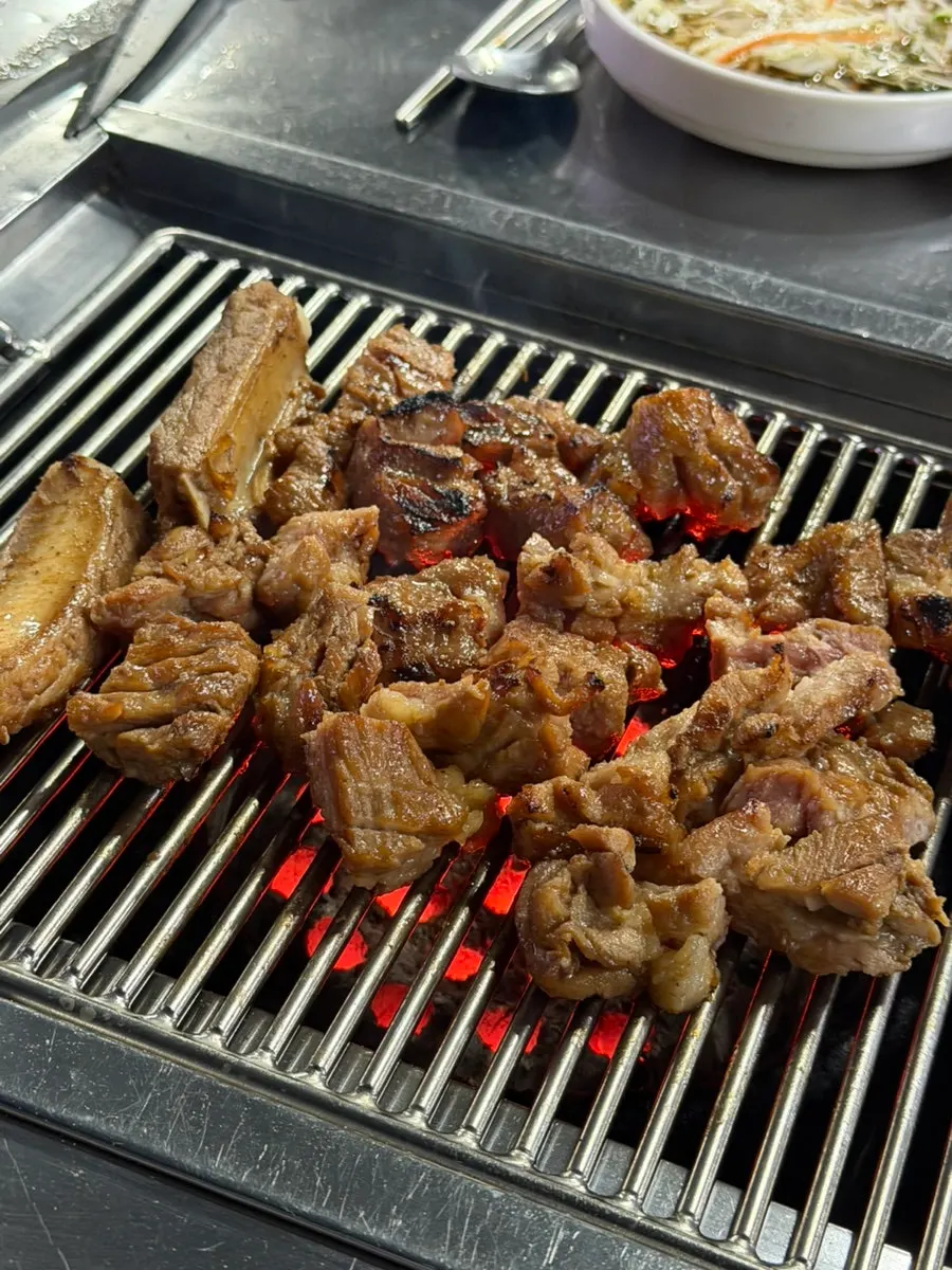 Close-up of pork ribs cooking over charcoal
