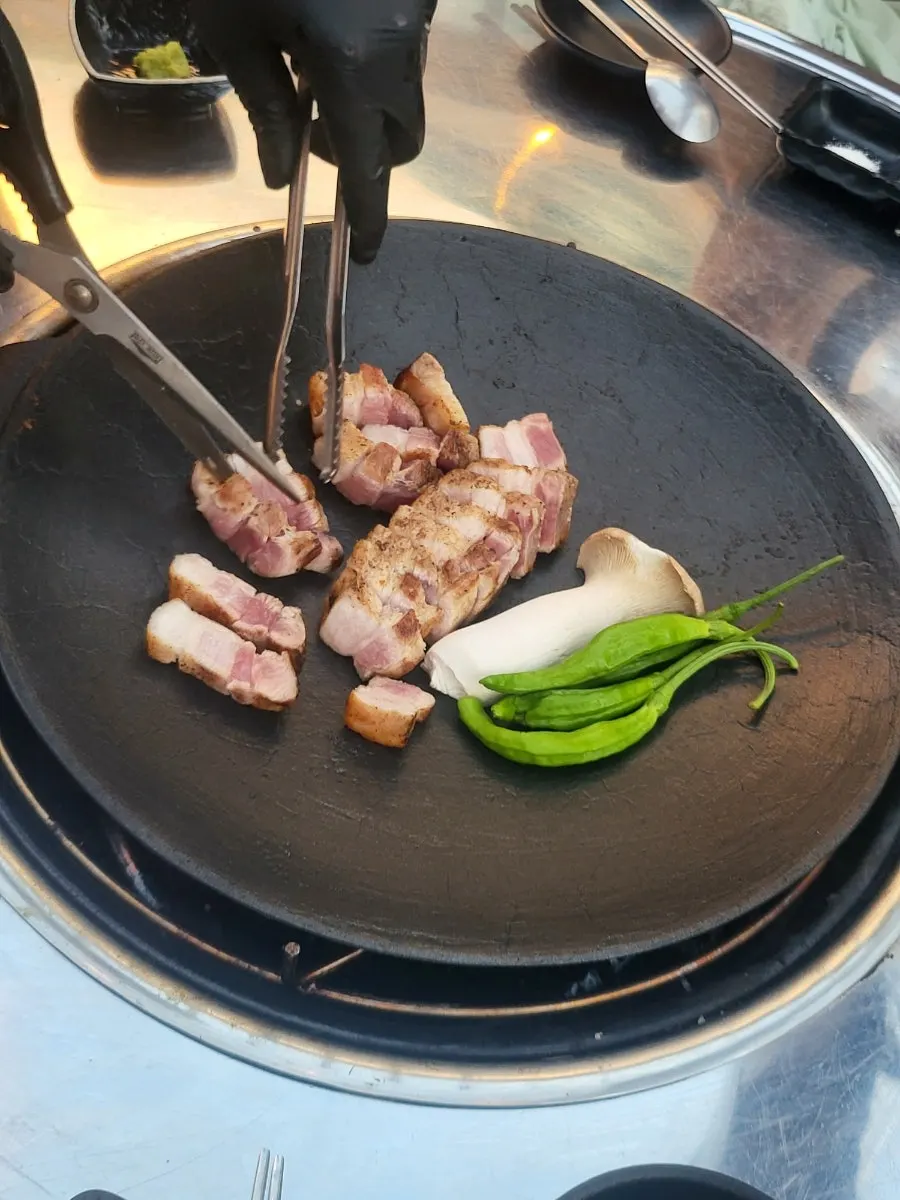 Pre-seared pork belly placed on the round griddle