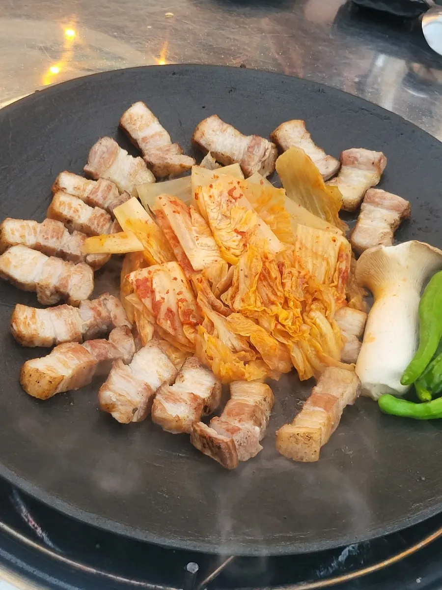 Cabbage kimchi grilling in the middle of the griddle