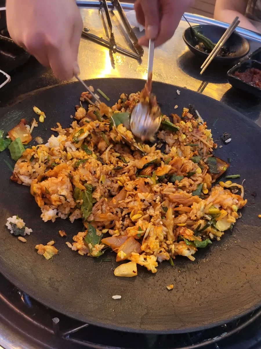 Finishing fried rice being cooked on the griddle