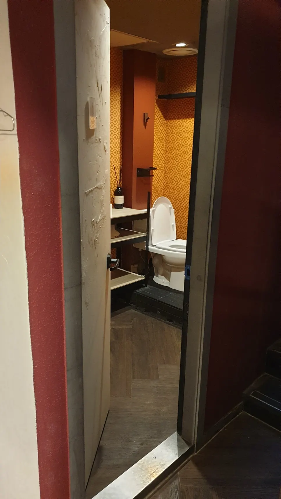 Passage to the restroom with a large mirror inside the restaurant