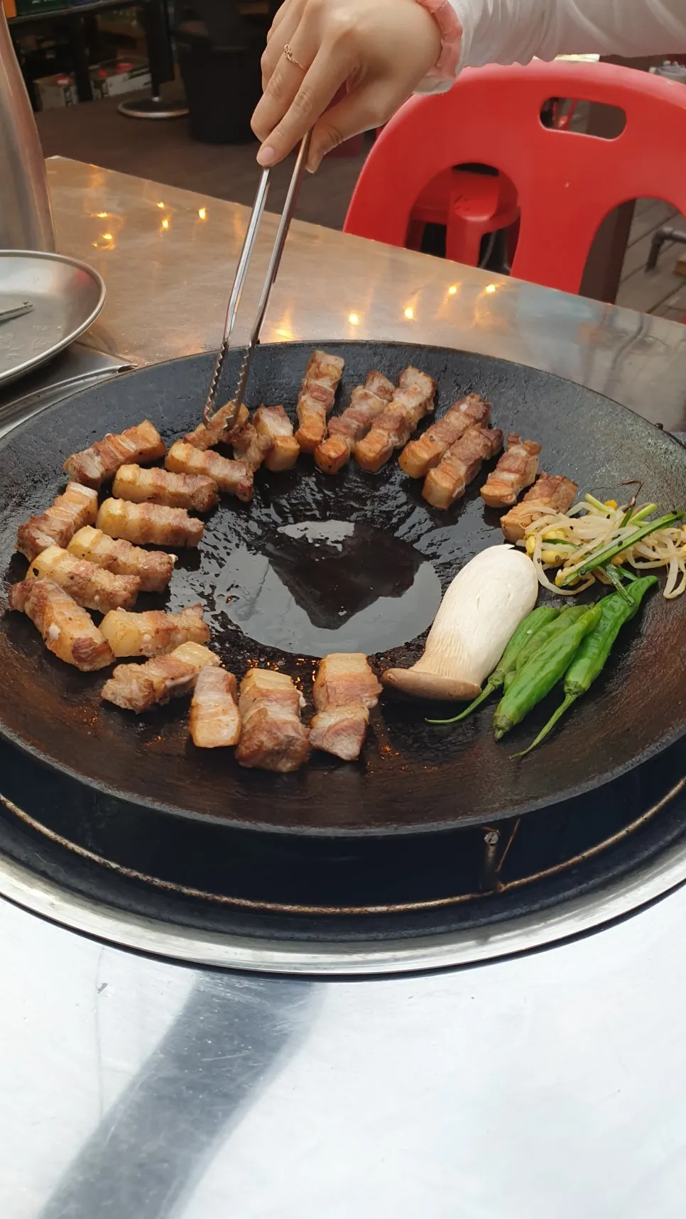 Pork belly grilled with kimchi in the center of the pan and vegetables around the edge